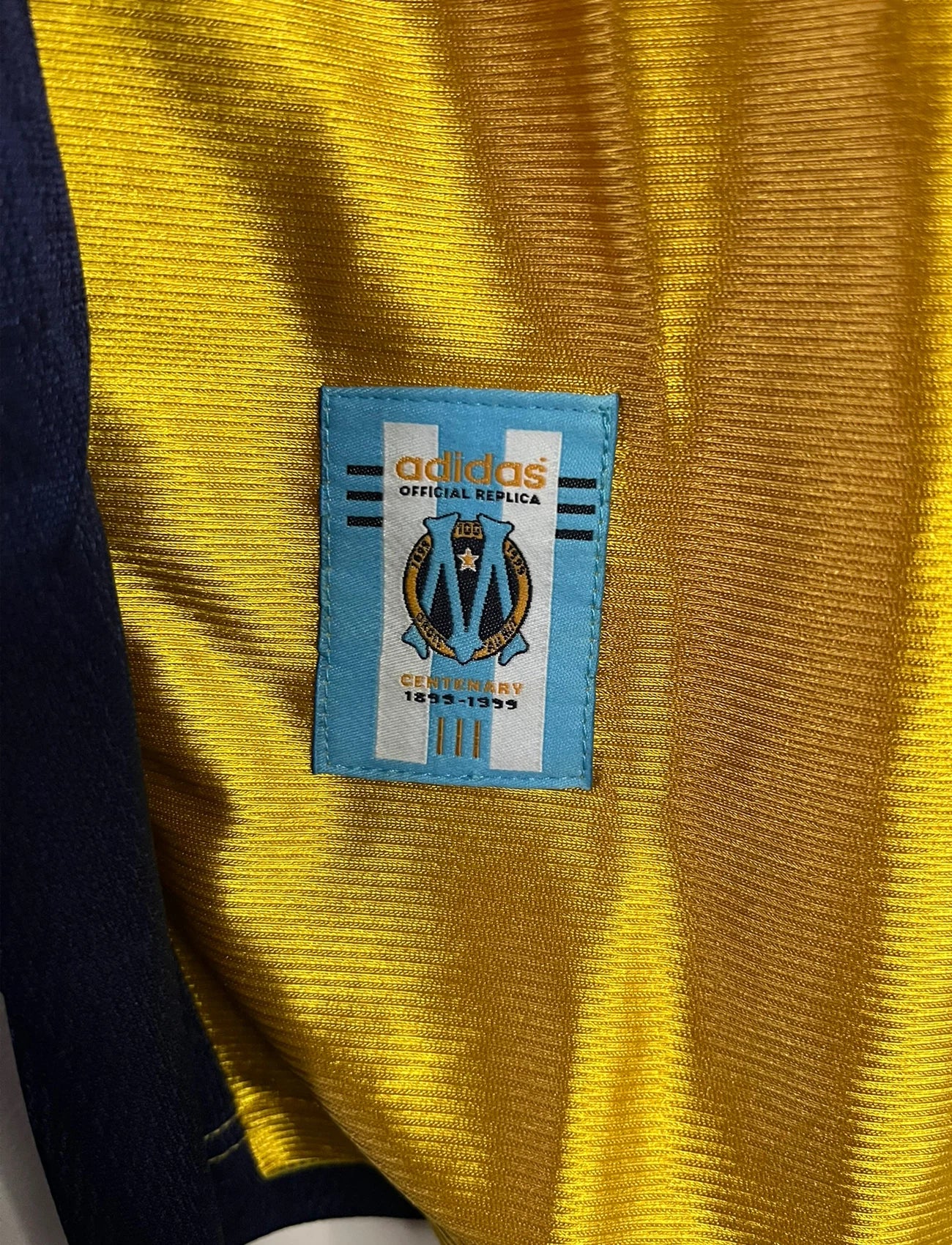 Maillot de foot vintage third doré de l'OM de la saison 1998/1999. On peut retrouver l'équipementier Adidas et le sponsor Ericsson. Il s'agit d'un maillot authentique d'époque.