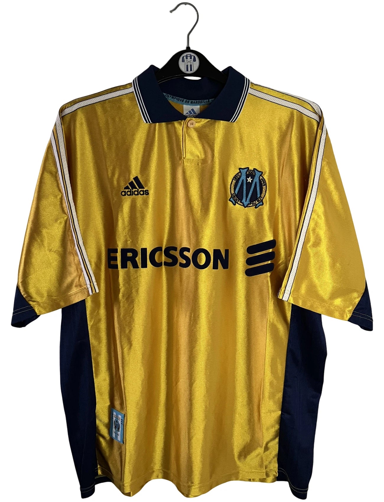 Maillot de foot vintage third doré de l'OM de la saison 1998/1999. On peut retrouver l'équipementier Adidas et le sponsor Ericsson. Il s'agit d'un maillot authentique d'époque.