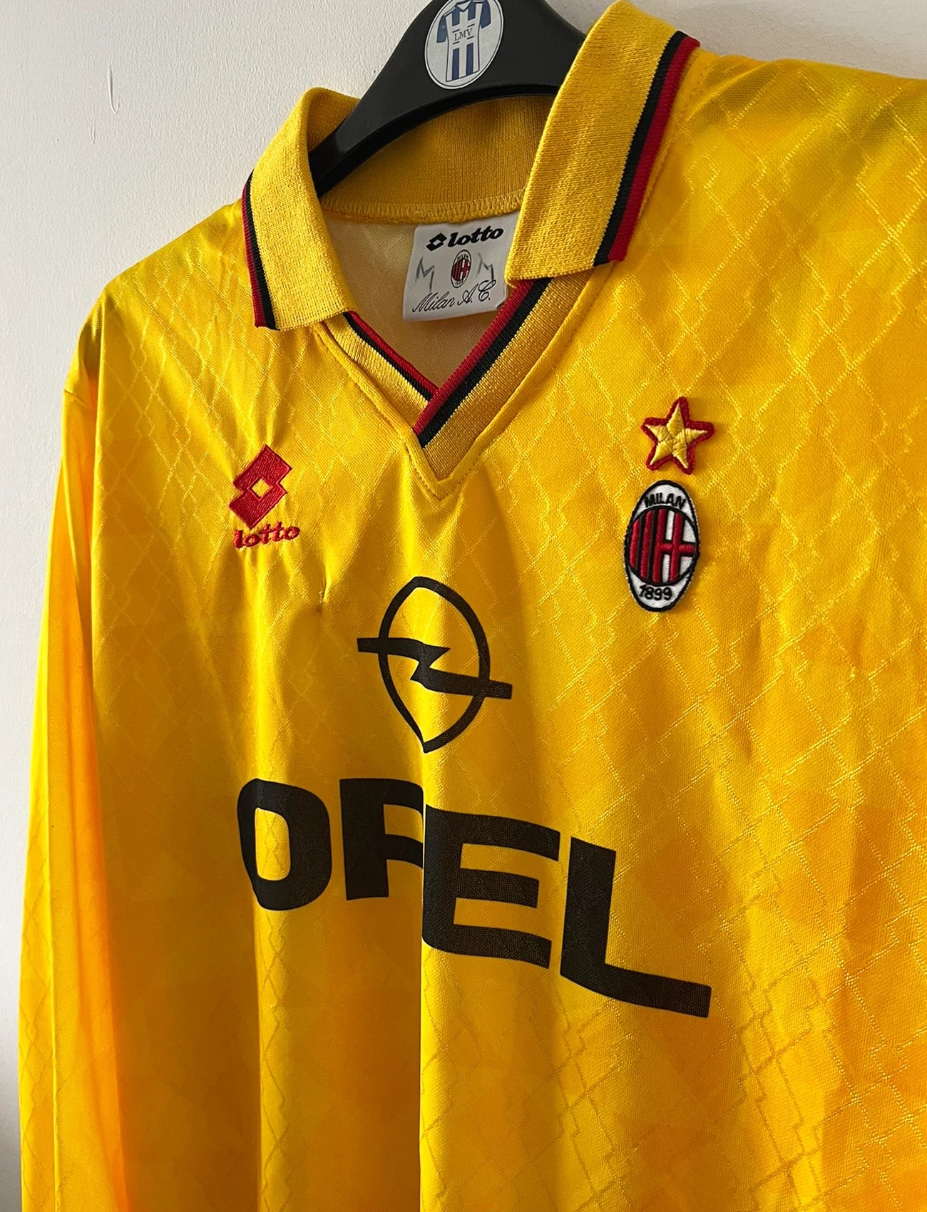 Maillot de foot vintage third jaune de l'AC Milan de la saison 1994/1996. On peut retrouver l'équipementier Lotto et le sponsor Opel. Il s'agit d'un maillot authentique d'époque.