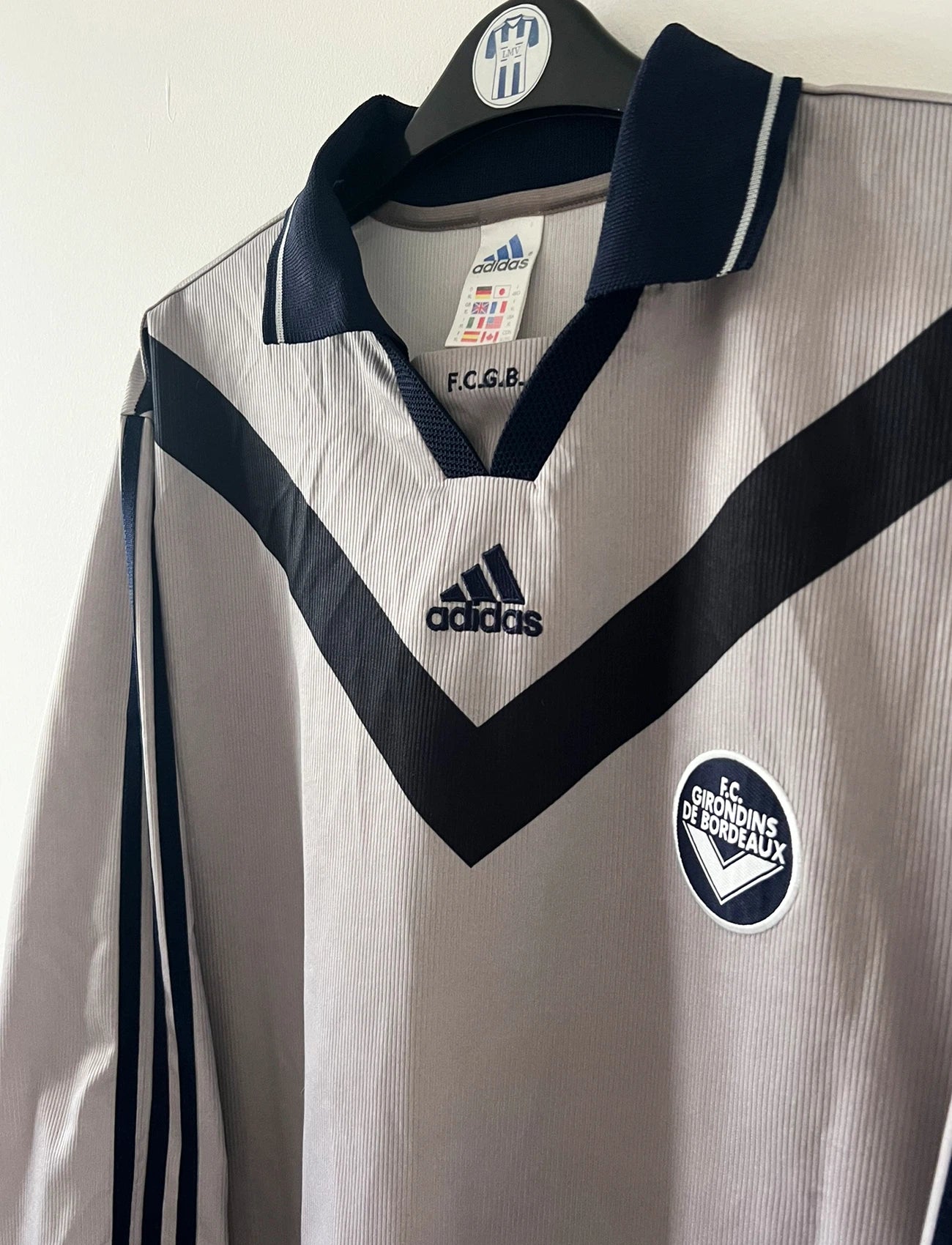 Maillot de foot vintage third gris des Girondins de Bordeaux saison 2000/2001. On peut retrouver l'équipementier Adidas. Il s'agit d'un maillot authentique et d'époque issu du stock pro du club.