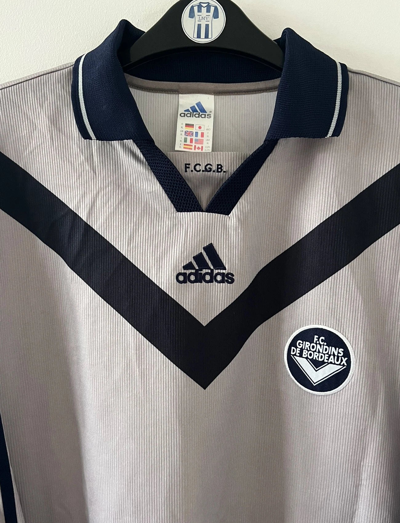 Maillot de foot vintage third gris des Girondins de Bordeaux saison 2000/2001. On peut retrouver l'équipementier Adidas. Il s'agit d'un maillot authentique et d'époque issu du stock pro du club.