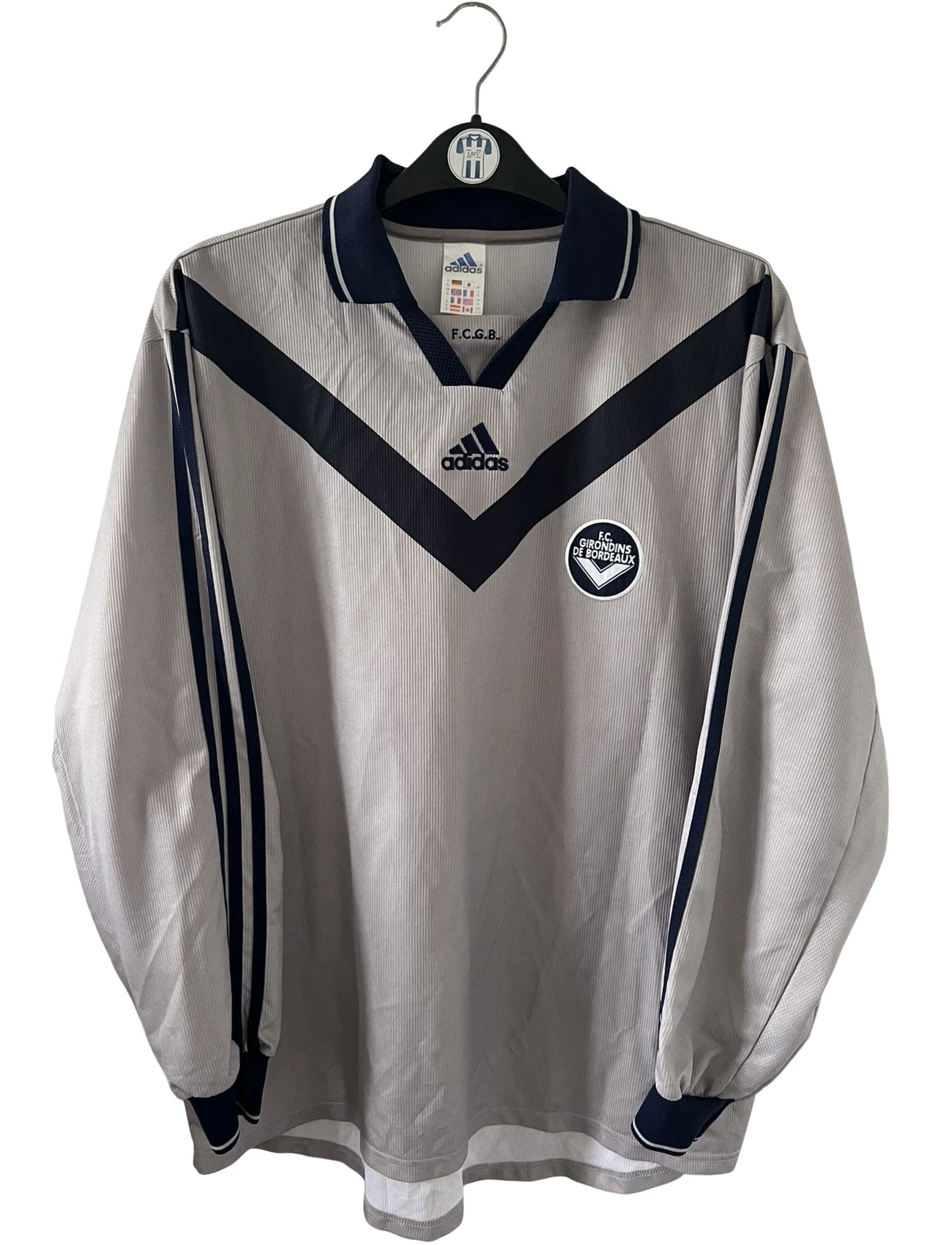 Maillot de foot vintage third gris des Girondins de Bordeaux saison 2000/2001. On peut retrouver l'équipementier Adidas. Il s'agit d'un maillot authentique et d'époque issu du stock pro du club.