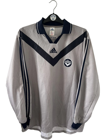 Maillot de foot vintage third gris des Girondins de Bordeaux saison 2000/2001. On peut retrouver l'équipementier Adidas. Il s'agit d'un maillot authentique et d'époque issu du stock pro du club.