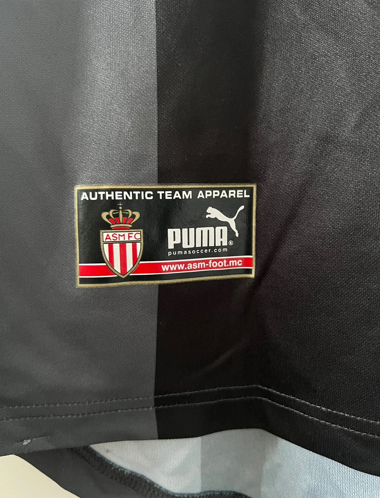 Maillot de foot vintage extérieur noir de l'AS Monaco saison 2002-2003. On peut retrouver l'équipementier Puma et le sponsor Fedcom. Il s'agit d'un maillot authentique d'époque.