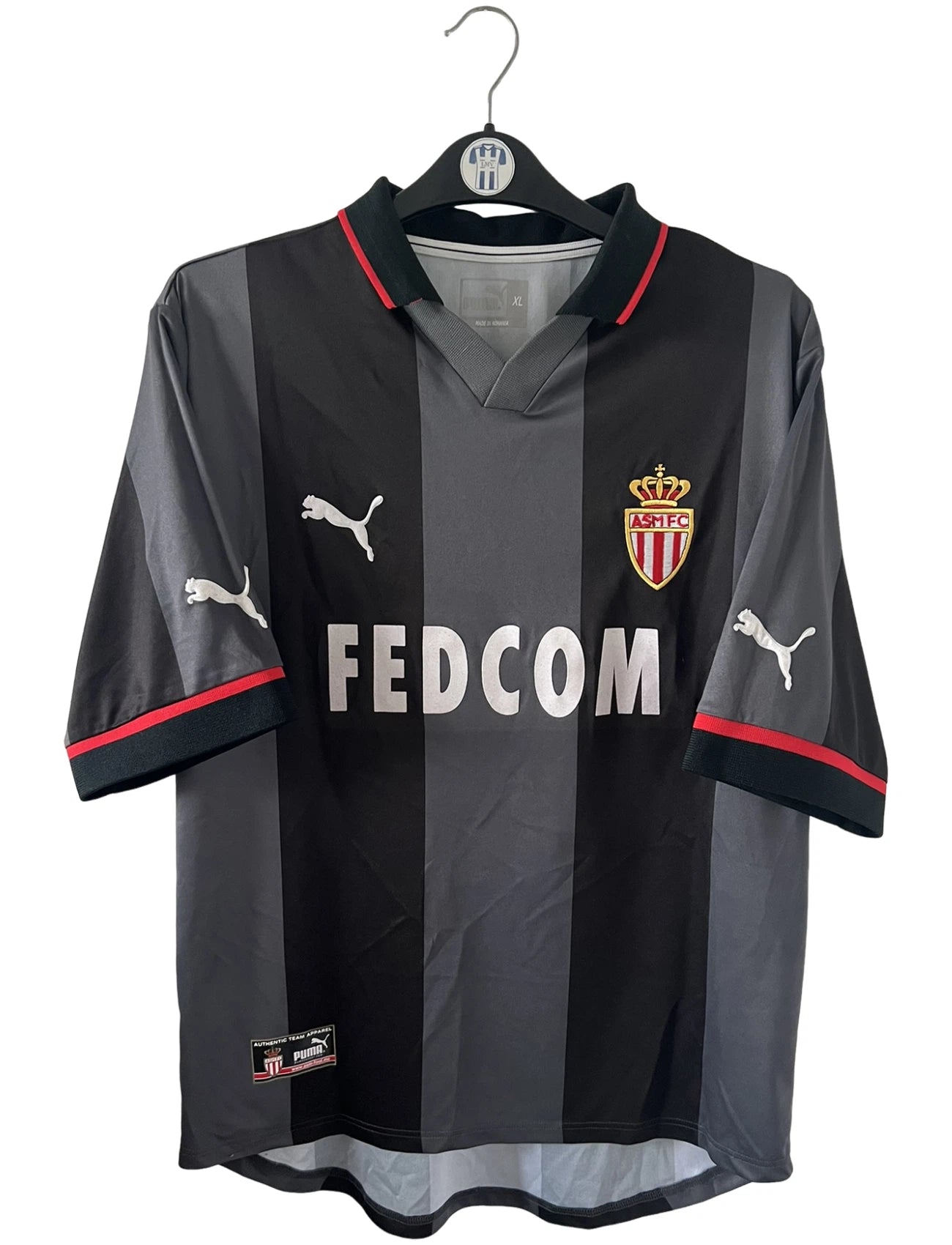 Maillot de foot vintage extérieur noir de l'AS Monaco saison 2002-2003. On peut retrouver l'équipementier Puma et le sponsor Fedcom. Il s'agit d'un maillot authentique d'époque.