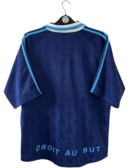 Maillot de foot vintage third bleu de l'om 1997/1998. On peut retrouver l'équipementier Adidas et le sponsor Ericsson. Il s'agit d'un maillot authentique d'époque.