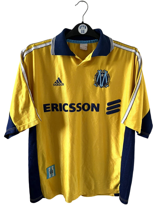 Maillot de foot vintage third doré de l'OM saison 1998/1999. On peut retrouver l'équipementier Adidas et le sponsor Ericsson. Il s'agit d'un maillot authentique d'époque.