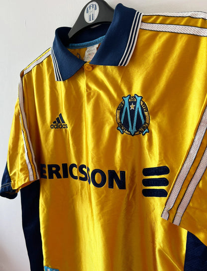 Maillot de foot vintage third doré de l'OM 1998/1999. On peut retrouver l'équipementier Adidas et le sponsor Ericsson. Il s'agit d'un maillot authentique d'époque.