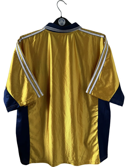 Maillot + short vintage third doré de l'OM 1998-1999. On peut retrouver l'équipementier Adidas et le sponsor Ericsson. Il s'agit d'un maillot et d'un short authentique d'époque.