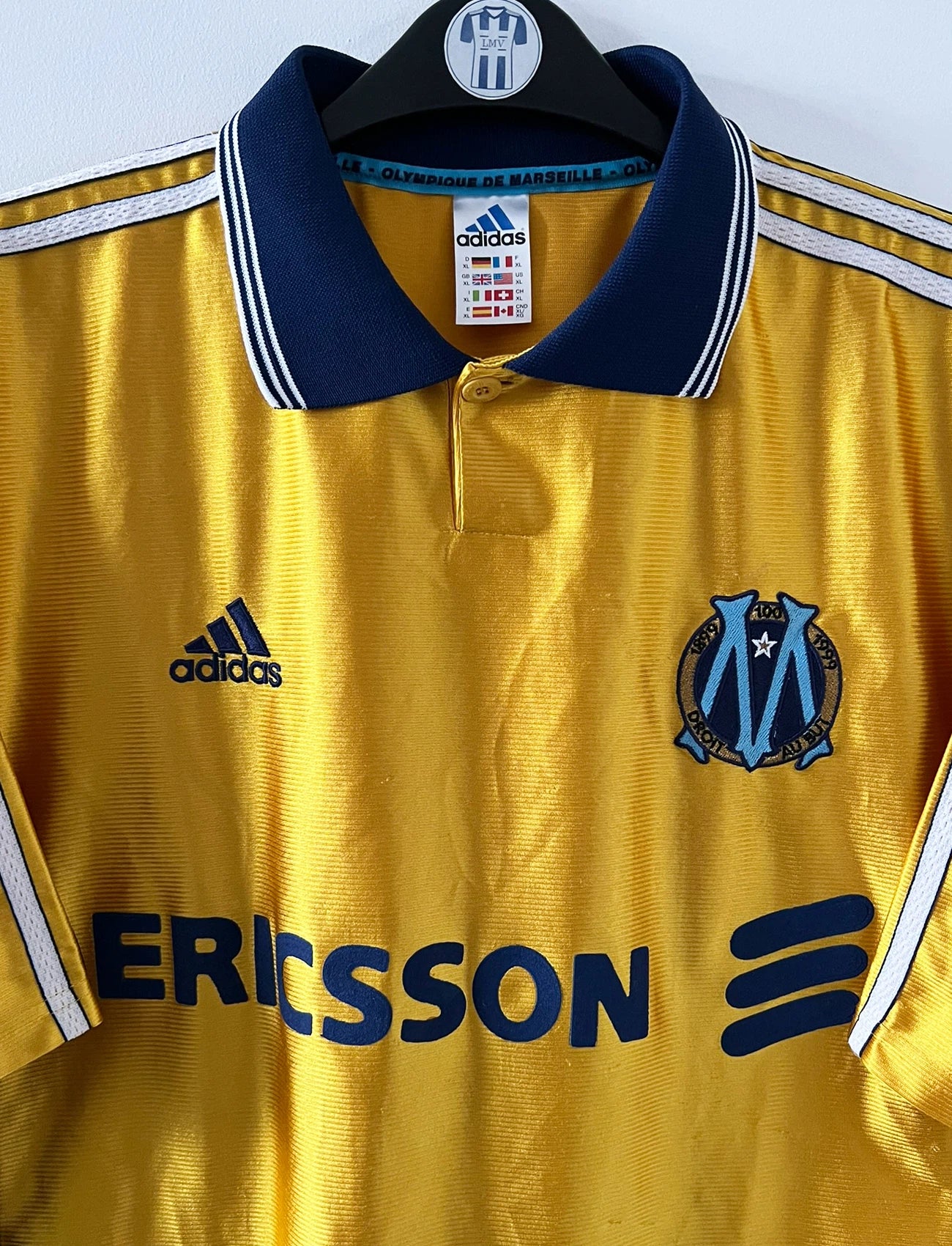 Maillot + short vintage third doré de l'OM 1998-1999. On peut retrouver l'équipementier Adidas et le sponsor Ericsson. Il s'agit d'un maillot et d'un short authentique d'époque.