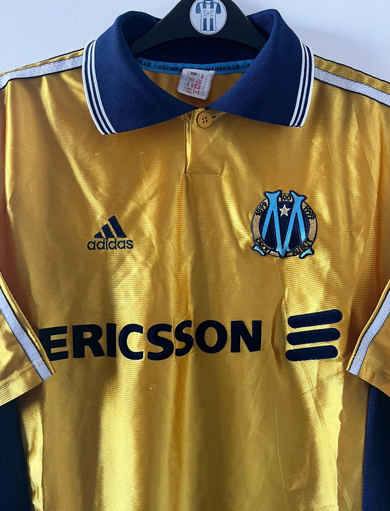 Maillot de foot vintage third doré de l'om 1998/1999. On peut retrouver l'équipementier Adidas et le sponsor Ericsson. Il s'agit d'un maillot authentique d'époque.