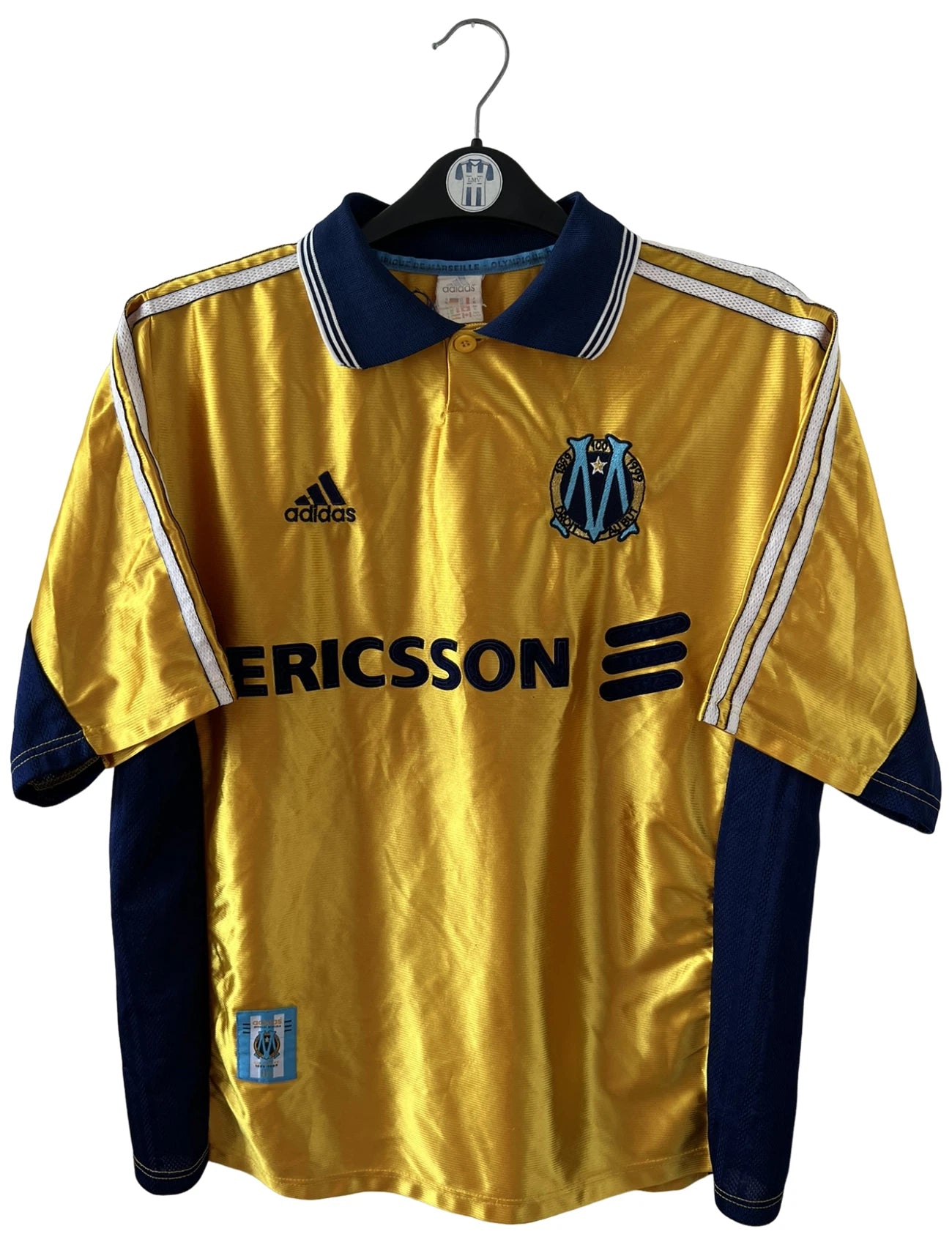 Maillot de foot vintage third doré de l'OM 1998/1999. On peut retrouver l'équipementier Adidas et le sponsor Ericsson. Il s'agit d'un maillot authentique d'époque.