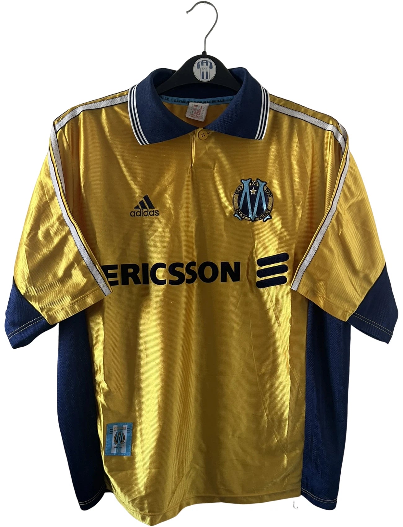 Maillot de foot vintage third doré de l'om 1998/1999. On peut retrouver l'équipementier Adidas et le sponsor Ericsson. Il s'agit d'un maillot authentique d'époque.