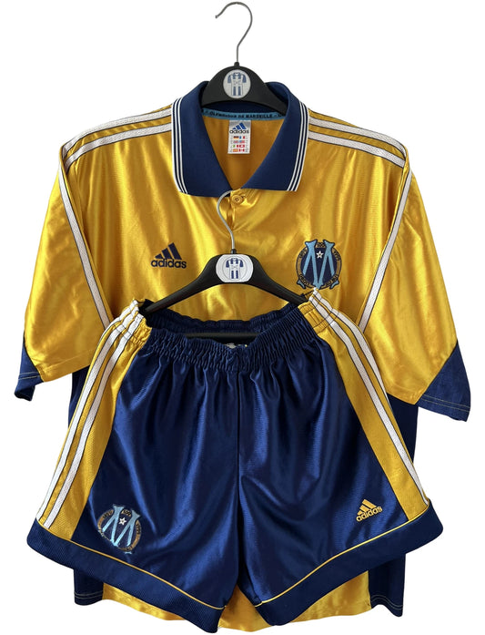 Maillot + short vintage third doré de l'OM 1998-1999. On peut retrouver l'équipementier Adidas et le sponsor Ericsson. Il s'agit d'un maillot et d'un short authentique d'époque.