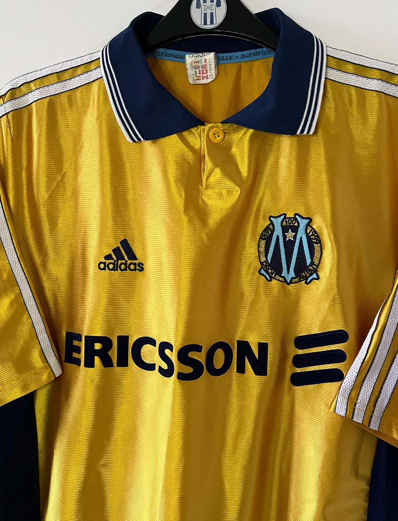 Maillot de foot vintage third doré de l'om 1998/1999. On peut retrouver l'équipementier Adidas et le sponsor Ericsson. Il s'agit d'un maillot authentique d'époque.