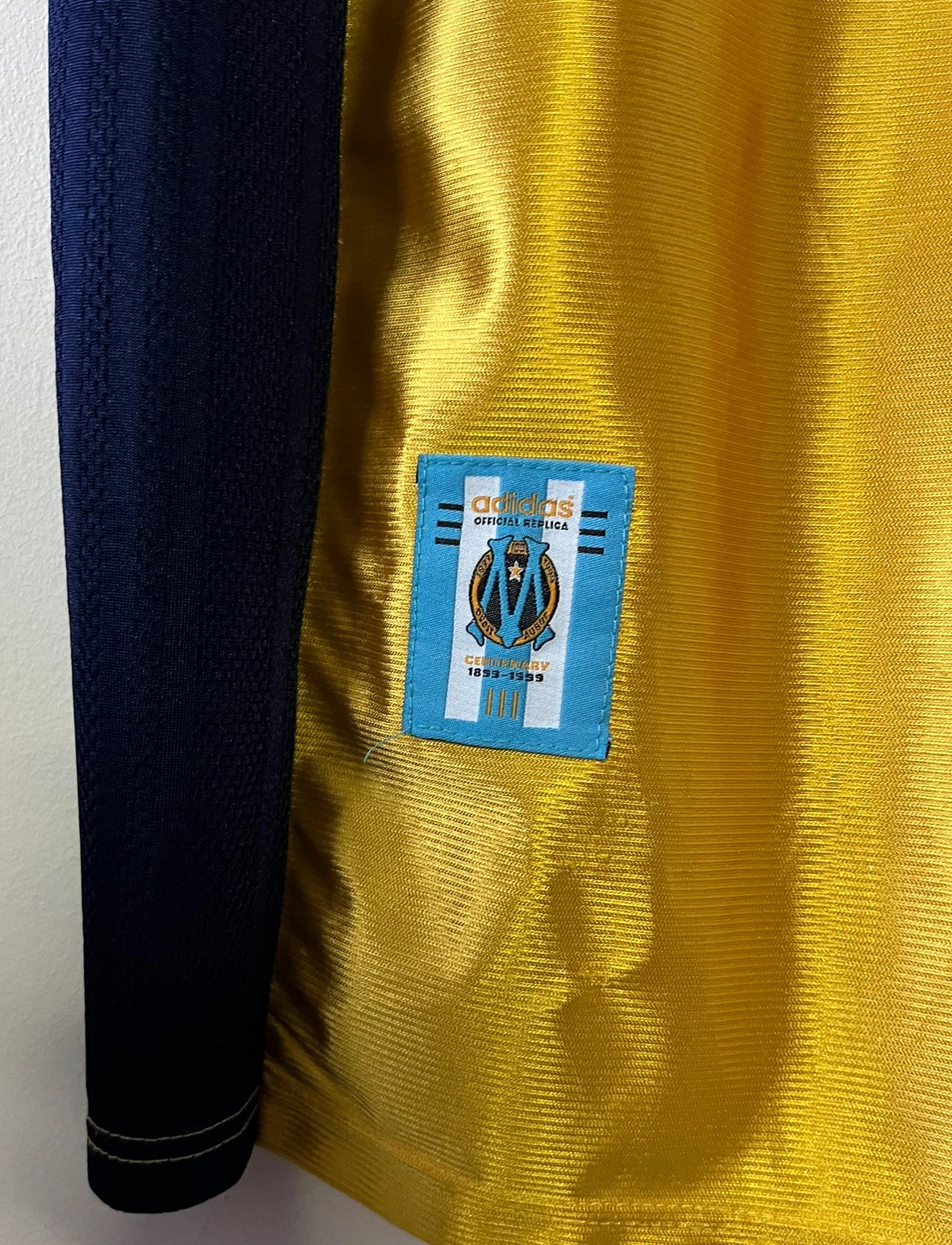 Maillot de foot vintage third doré de l'om 1998/1999. On peut retrouver l'équipementier Adidas et le sponsor Ericsson. Il s'agit d'un maillot authentique d'époque.