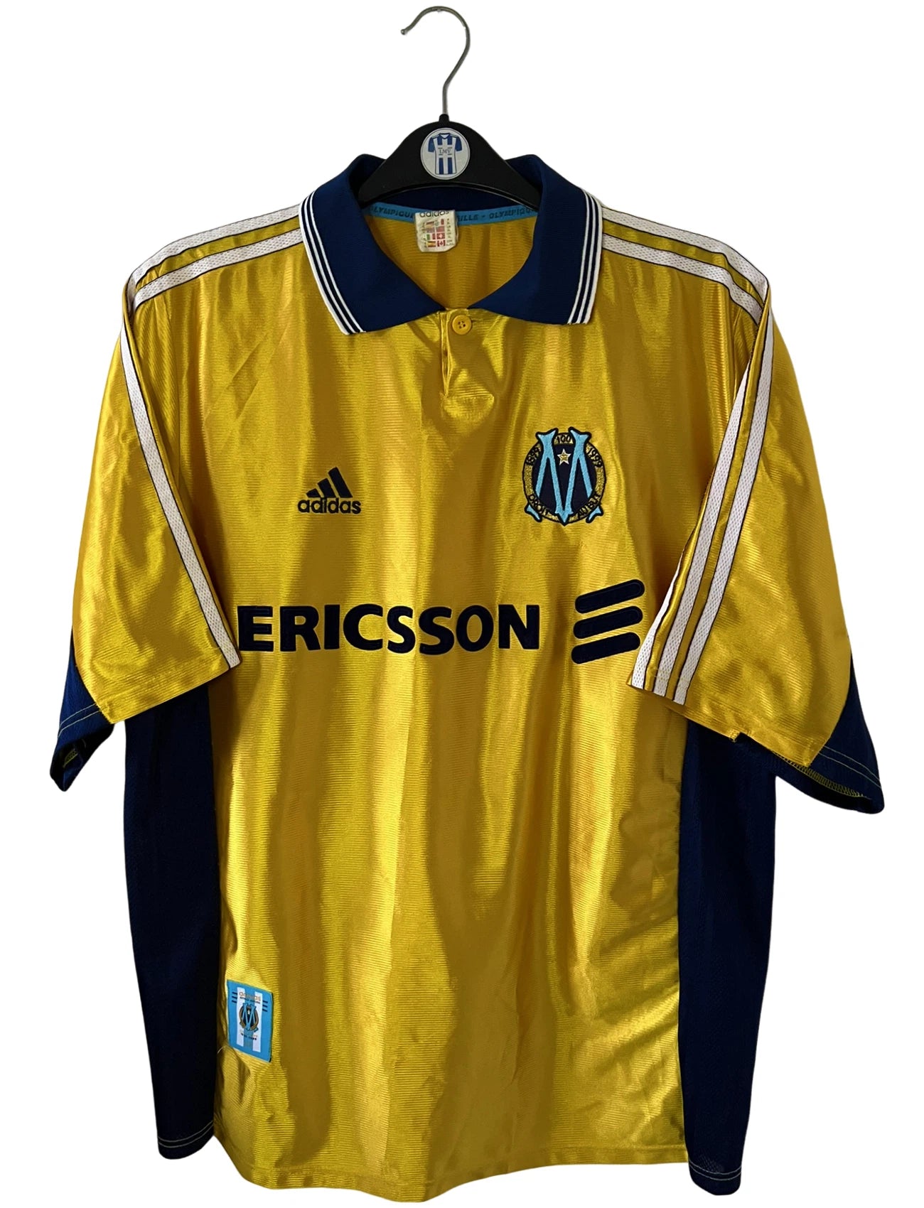 Maillot de foot vintage third doré de l'om 1998/1999. On peut retrouver l'équipementier Adidas et le sponsor Ericsson. Il s'agit d'un maillot authentique d'époque.
