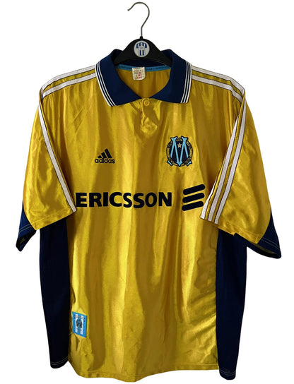 Maillot de foot vintage third doré de l'om 1998/1999. On peut retrouver l'équipementier Adidas et le sponsor Ericsson. Il s'agit d'un maillot authentique d'époque.