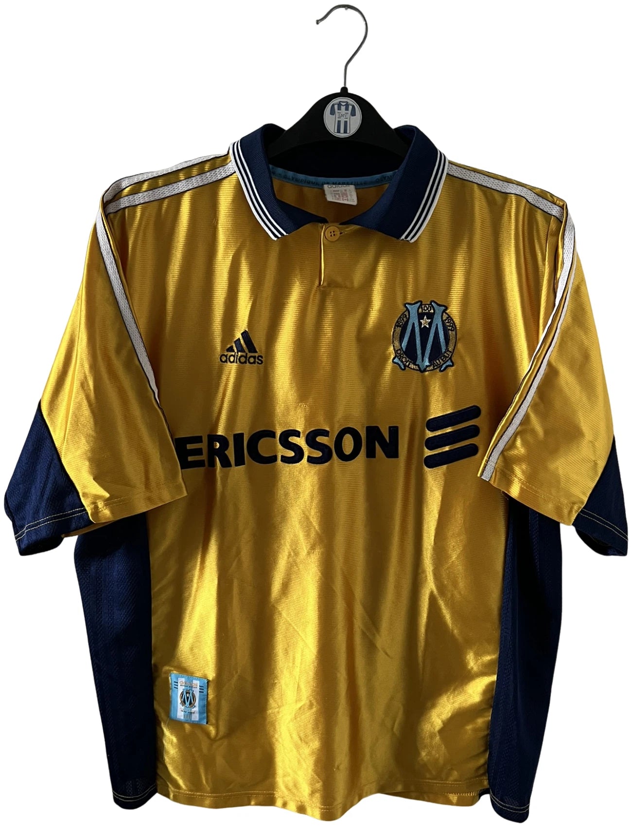 Maillot de foot vintage third doré de l'om 1998/1999. On peut retrouver l'équipementier Adidas et le sponsor Ericsson. Il s'agit d'un maillot authentique d'époque.