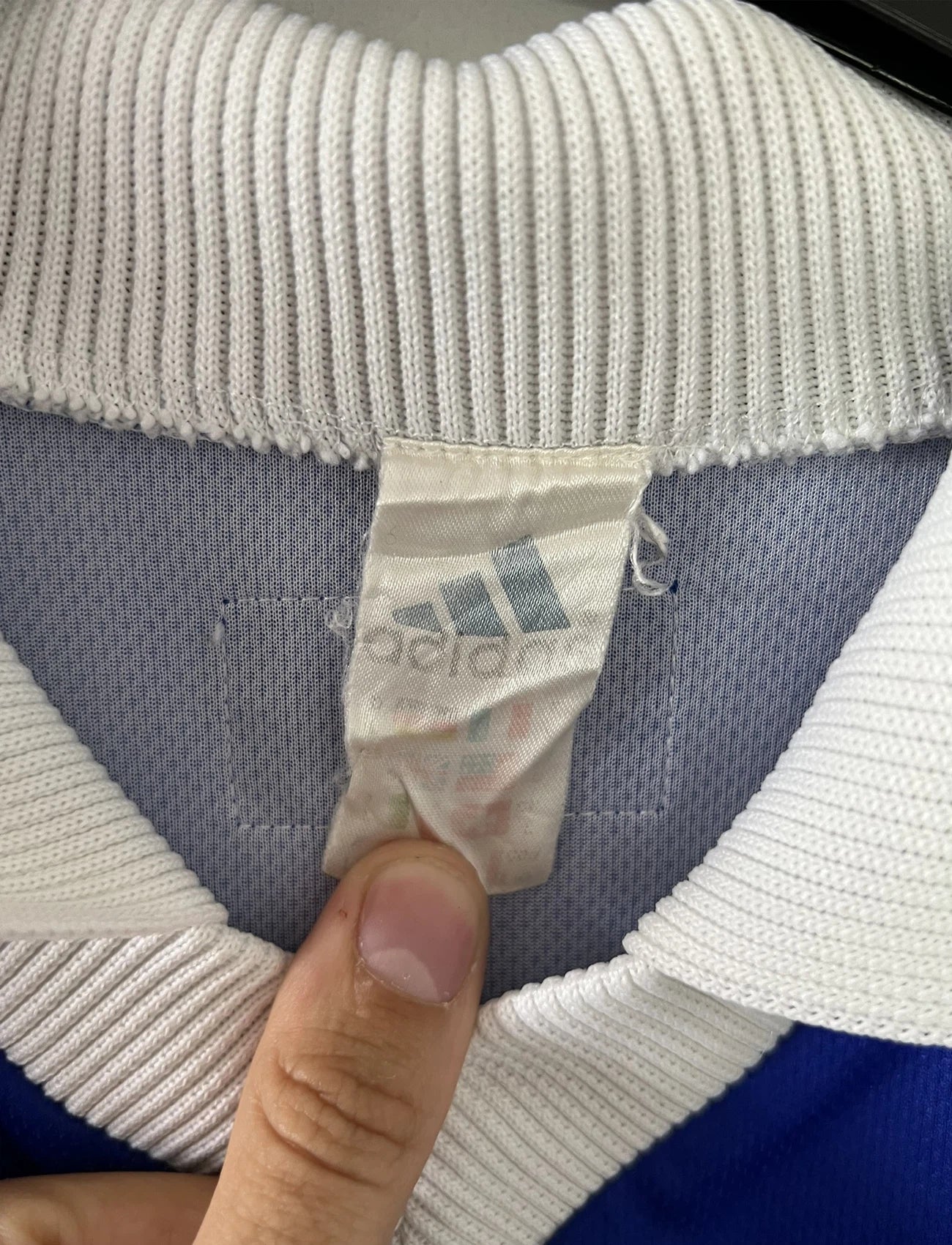 Maillot de foot vintage bleu, blanc et rouge de l'équipe de france 1998. On peut retrouver l'équipementier adidas. Il s'agit d'un maillot authentique édité avant la finale de la coupe du monde car celui-ci ne possède pas l'étoile.