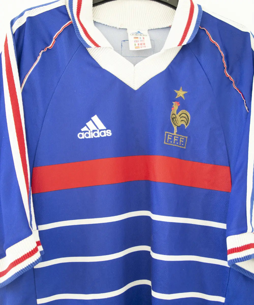 Maillot domicile bleu blanc et rouge de l'équipe de france 1998. On peut retrouver l'équipementier adidas. Le maillot est floqué du numéro 10 Zinedine zidane