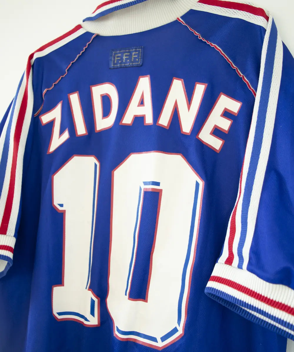 Maillot domicile bleu blanc et rouge de l'équipe de france 1998. On peut retrouver l'équipementier adidas. Le maillot est floqué du numéro 10 Zinedine zidane