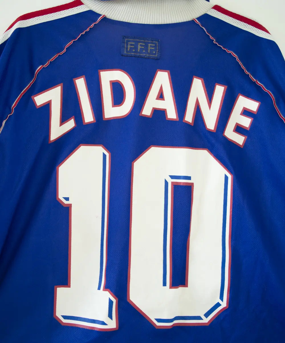 Maillot domicile bleu blanc et rouge de l'équipe de france 1998. On peut retrouver l'équipementier adidas. Le maillot est floqué du numéro 10 Zinedine zidane