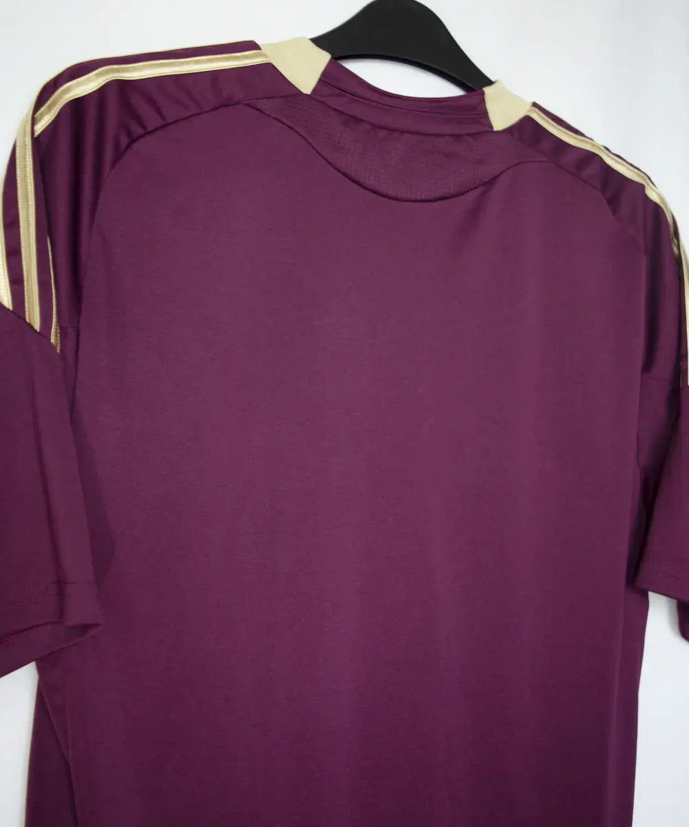 Maillot extérieur de l'ol de la saison 2010-2011. Le maillot est de couleur violet et dorée. On peut retrouver l'équipementier adidas et le sponsor everest poker