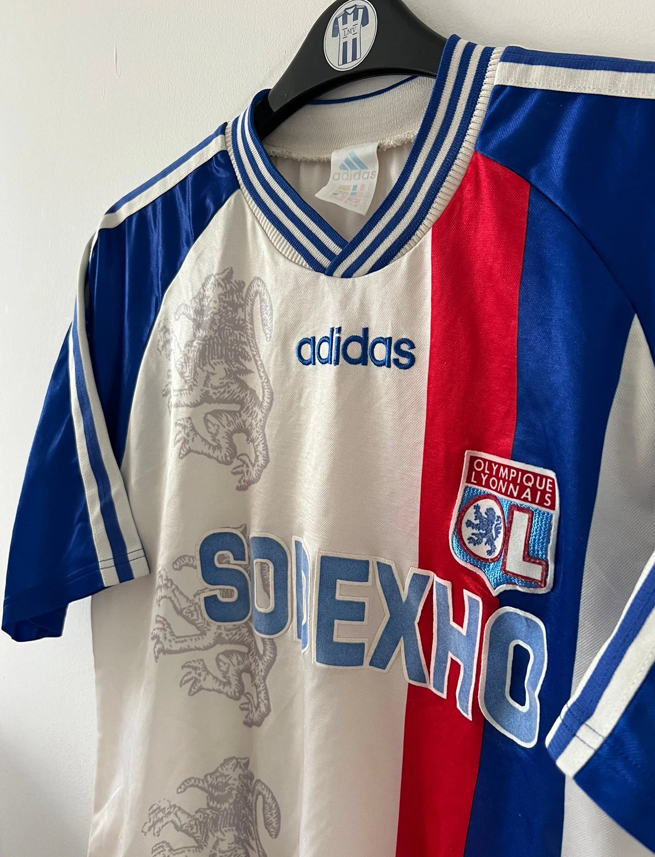 Maillot de foot vintage domicile blanc de l'Olympique Lyonnais saison 1996/1998. On peut retrouver l'équipementier Adidas et le sponsor Sodexho. Il s'agit d'un maillot authentique d'époque.