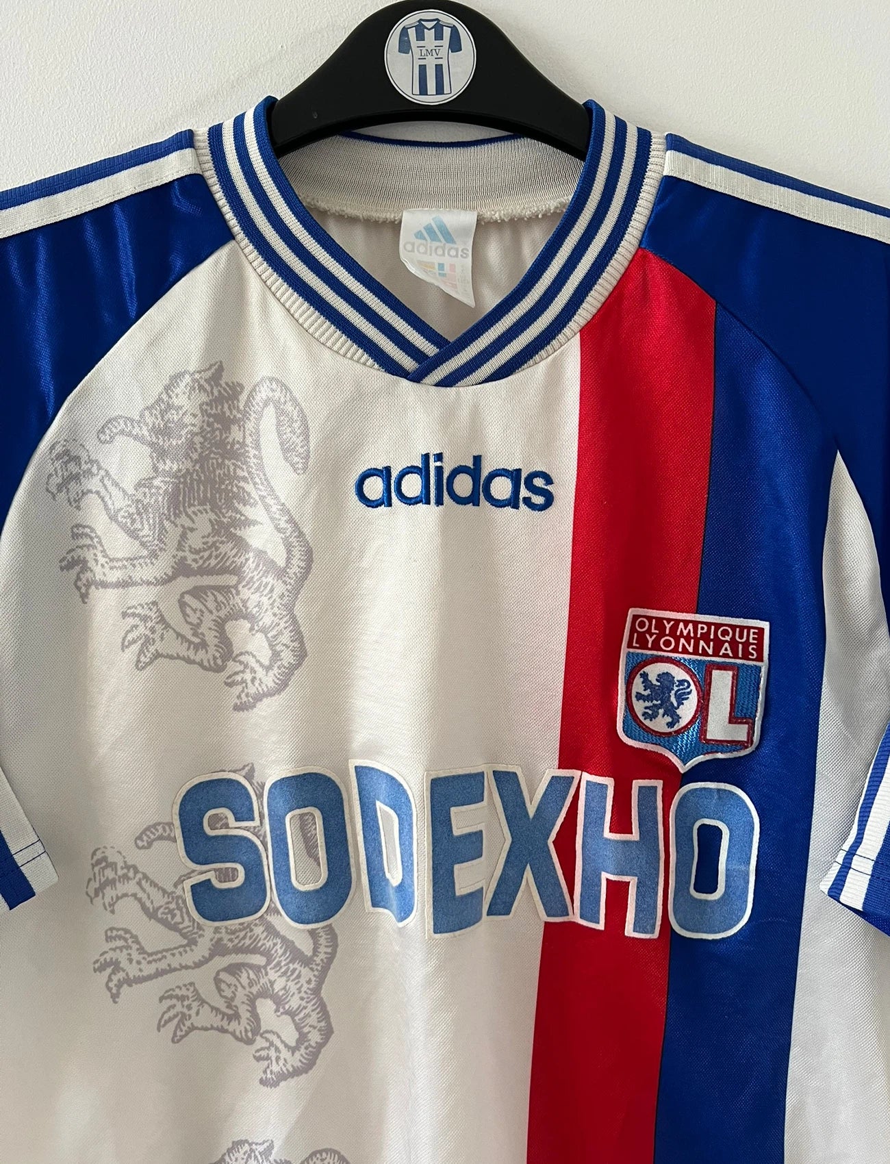 Maillot de foot vintage domicile blanc de l'Olympique Lyonnais saison 1996/1998. On peut retrouver l'équipementier Adidas et le sponsor Sodexho. Il s'agit d'un maillot authentique d'époque.