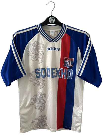Maillot de foot vintage domicile blanc de l'Olympique Lyonnais saison 1996/1998. On peut retrouver l'équipementier Adidas et le sponsor Sodexho. Il s'agit d'un maillot authentique d'époque.