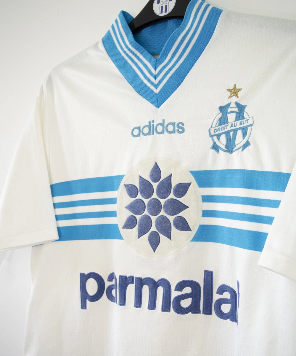 Maillot de foot vintage domicile blanc et bleu de l'om de la saison 1996/1997. On peut retrouver l'équipementier adidas et le sponsor Parmalat. Il s'agit d'un maillot authentique