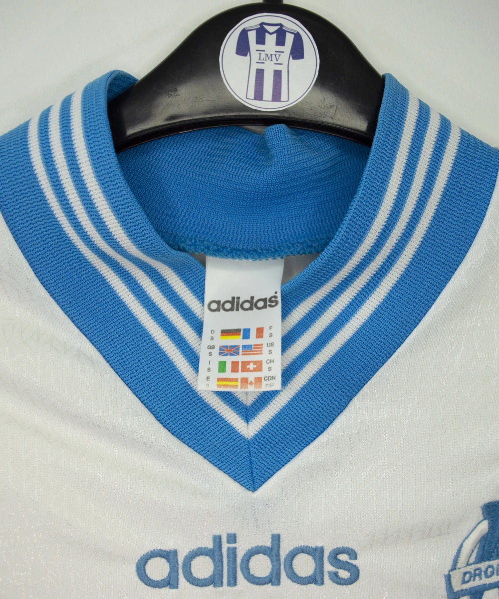 Maillot de foot vintage domicile blanc et bleu de l'om de la saison 1996/1997. On peut retrouver l'équipementier adidas et le sponsor Parmalat. Il s'agit d'un maillot authentique