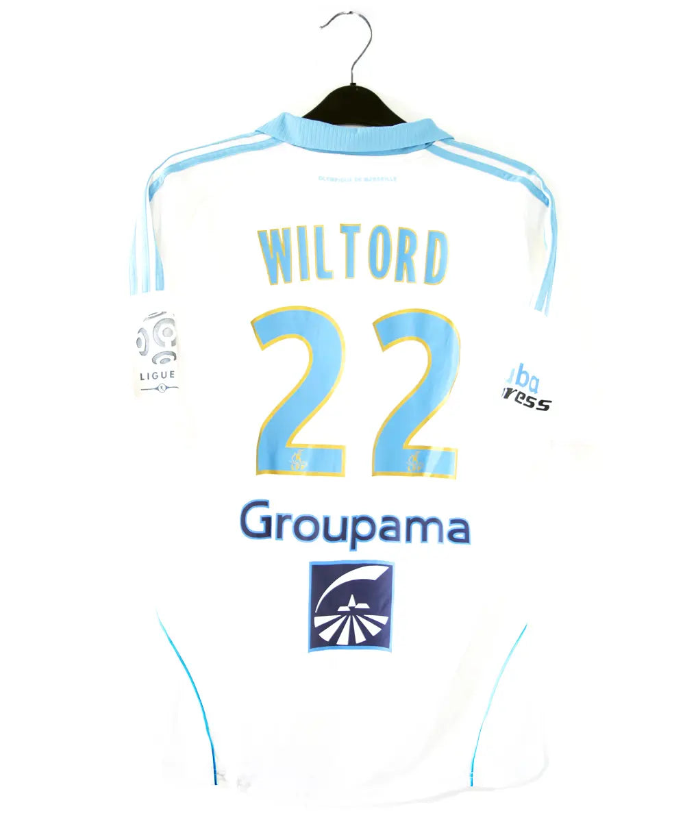 Maillot domicile blanc et bleu de l'om de la saison 2008-2009. Le maillot est floqué du numero 22 Wiltord