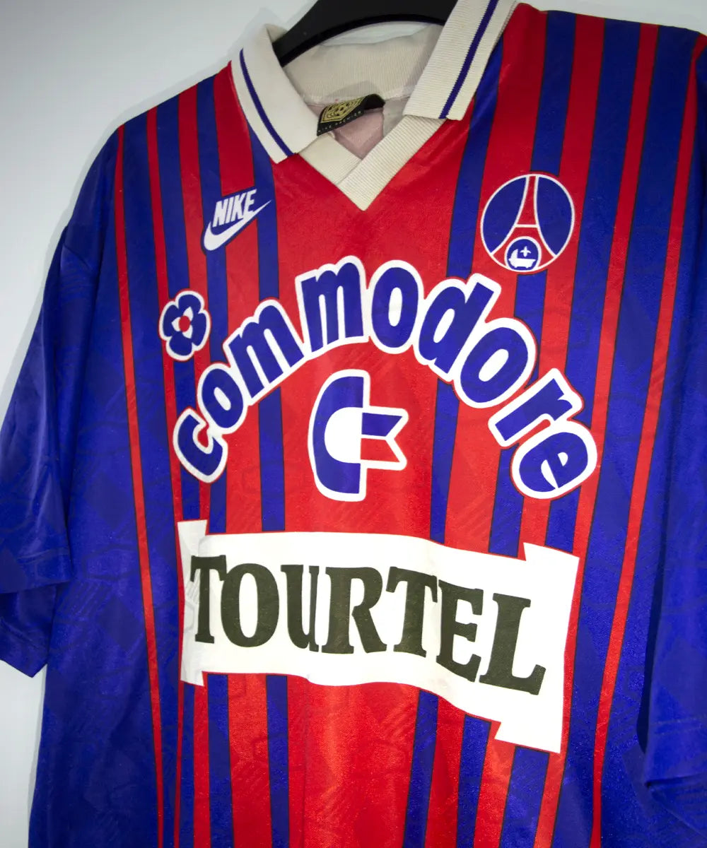 Maillot vintage domicile rouge et bleu du PSG de la saison 1993/1994. On peut retrouver l'équipementier nike, le sponsor commodore et le sponsor tourtel