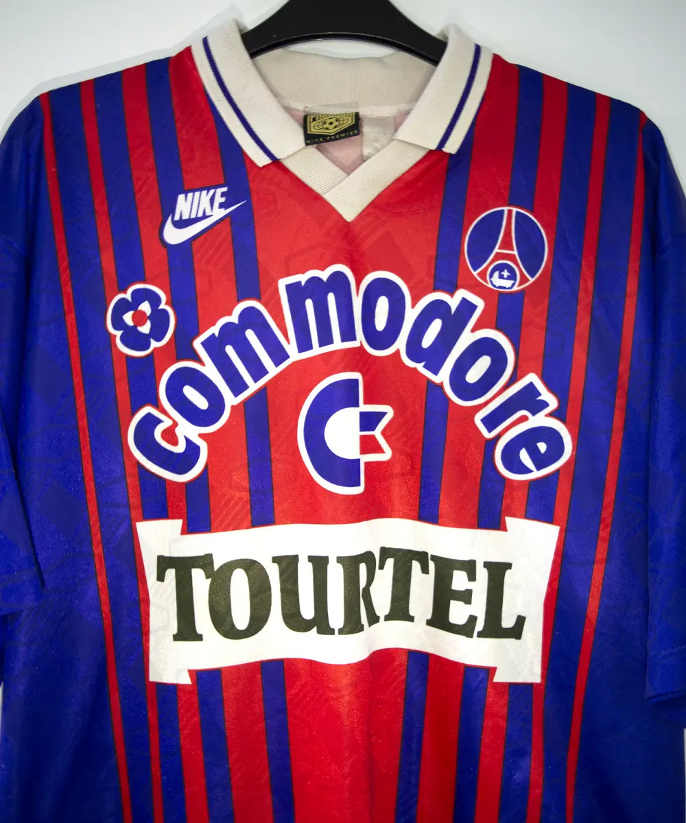 Maillot vintage domicile rouge et bleu du PSG de la saison 1993/1994. On peut retrouver l'équipementier nike, le sponsor commodore et le sponsor tourtel