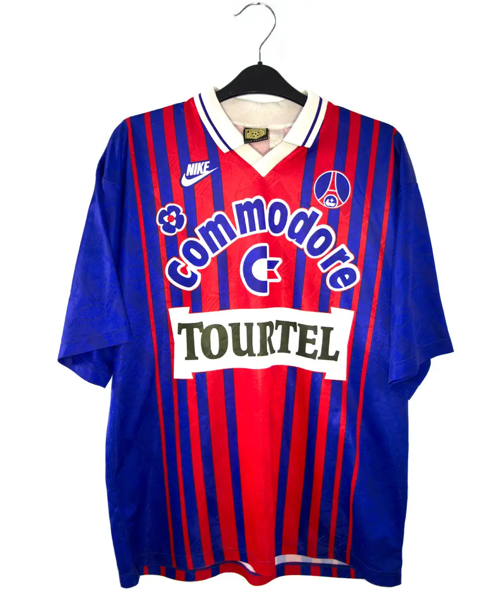 Maillot vintage domicile rouge et bleu du PSG de la saison 1993/1994. On peut retrouver l'équipementier nike, le sponsor commodore et le sponsor tourtel