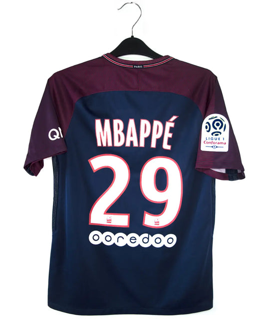 Maillot domicile du psg de la saison 2017-2018 de couleur bleu et rouge. On peut retrouver l'équipementier nike et le sponsor fly emirates. Le maillot est floqué du numéro 29 Mbappé