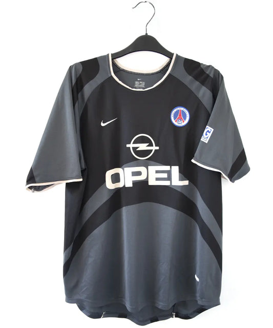 Maillot third du PSG de la saison 2001-2002. Le maillot est de couleur noir et gris. On peut retrouver le sponsor Opel ainsi que l'équipementier Nike.