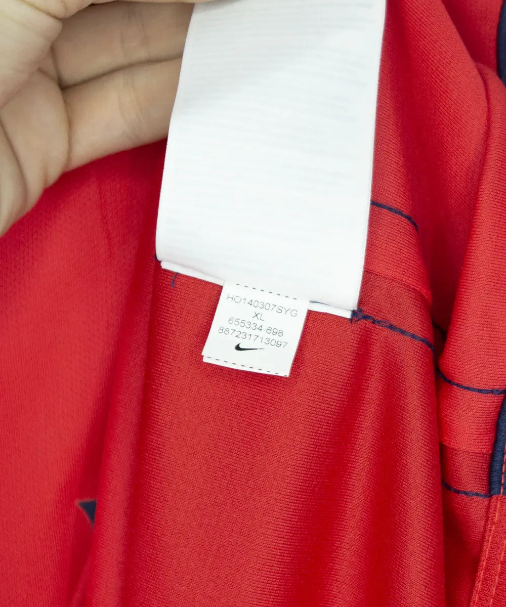 Maillot rouge et bleu third du psg de la saison 2014-2015. On peut retrouver l'équipementier nike et le sponsor fly emirates. Le maillot est floqué du numéro 32 David Luis. Sur cette photo on peut voir l'étiquette comportant les numéros 655334-698