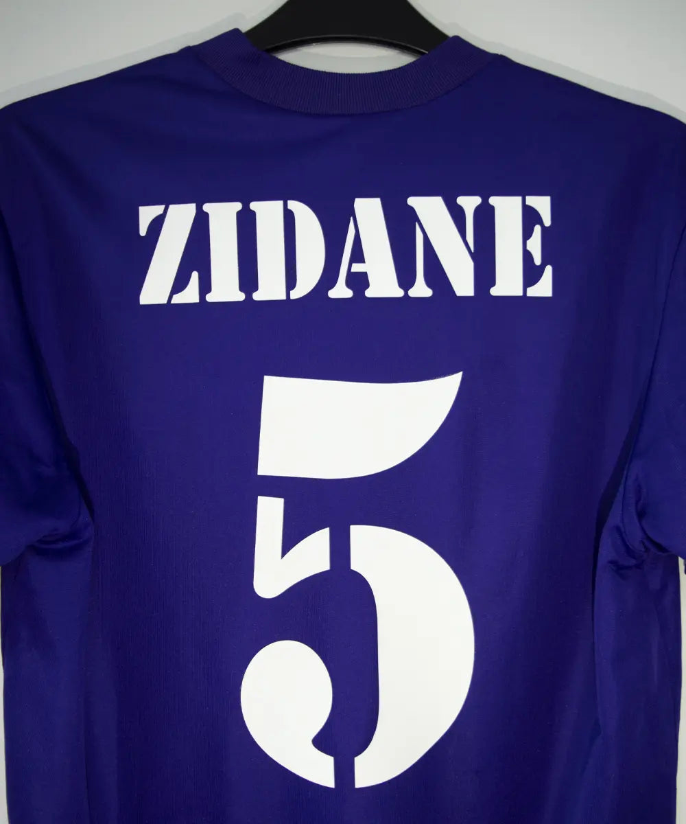Maillot vintage violet et blanc third du real madrid de la saison 2002-2003. On peut retrouver l'équipementier adidas et le sponsor siemens mobile. Il s'agit du maillot du centenaire. Le maillot est floqué du numéro 5 Zinedine Zidane