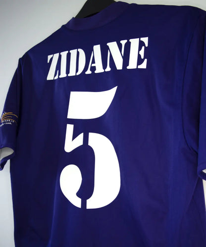 Maillot vintage third violet du real madrid de la saison 2002-2003. Il s'agit du maillot édité pour les 100 ans du club. On peut retrouver l'équipementier adidas. Le maillot est réversible. Le maillot est floqué du numéro 5 Zinedine Zidane