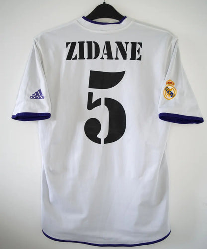 Maillot vintage third violet du real madrid de la saison 2002-2003. Il s'agit du maillot édité pour les 100 ans du club. On peut retrouver l'équipementier adidas. Le maillot est réversible. Le maillot est floqué du numéro 5 Zinedine Zidane