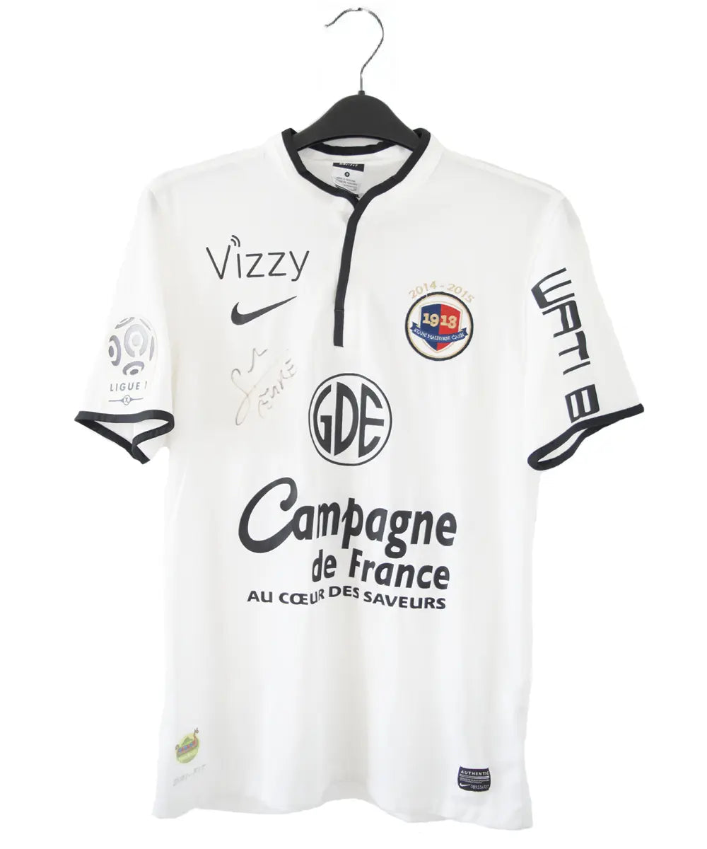 Maillot third du SM Caen de la saison 2014-2015 de couleur blanc et noir. On peut retrouver l'équipementier nike, le sponsor GDE et le sponsor SAS Malus. Le maillot est floqué du numéro 2 Nicolas Seube. Le maillot est aussi signé par Seube