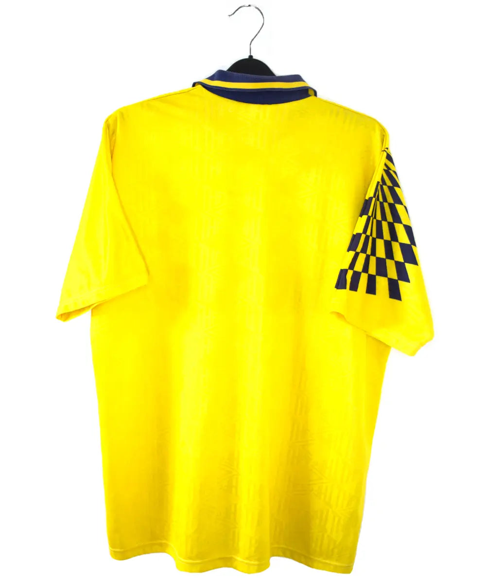 Maillot extérieur de Tottenham de la saison 1991-1995 de couleur jaune. On peut retrouver l'équipementier Umbro et le sponsor Holsten