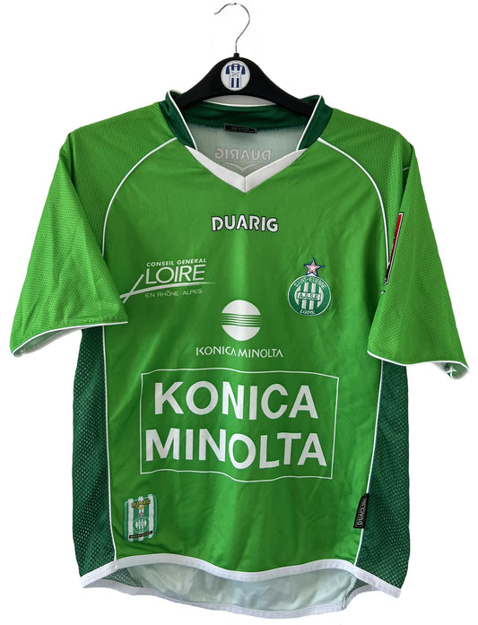 Maillot de foot vintage domicile de l'ASSE de la saison 2004-2005. Le maillot est de couleur vert et blanc. On peut retrouver l'équipementier duarig et le sponsor Konica Minolta. Il s'agit d'un maillot authentique.