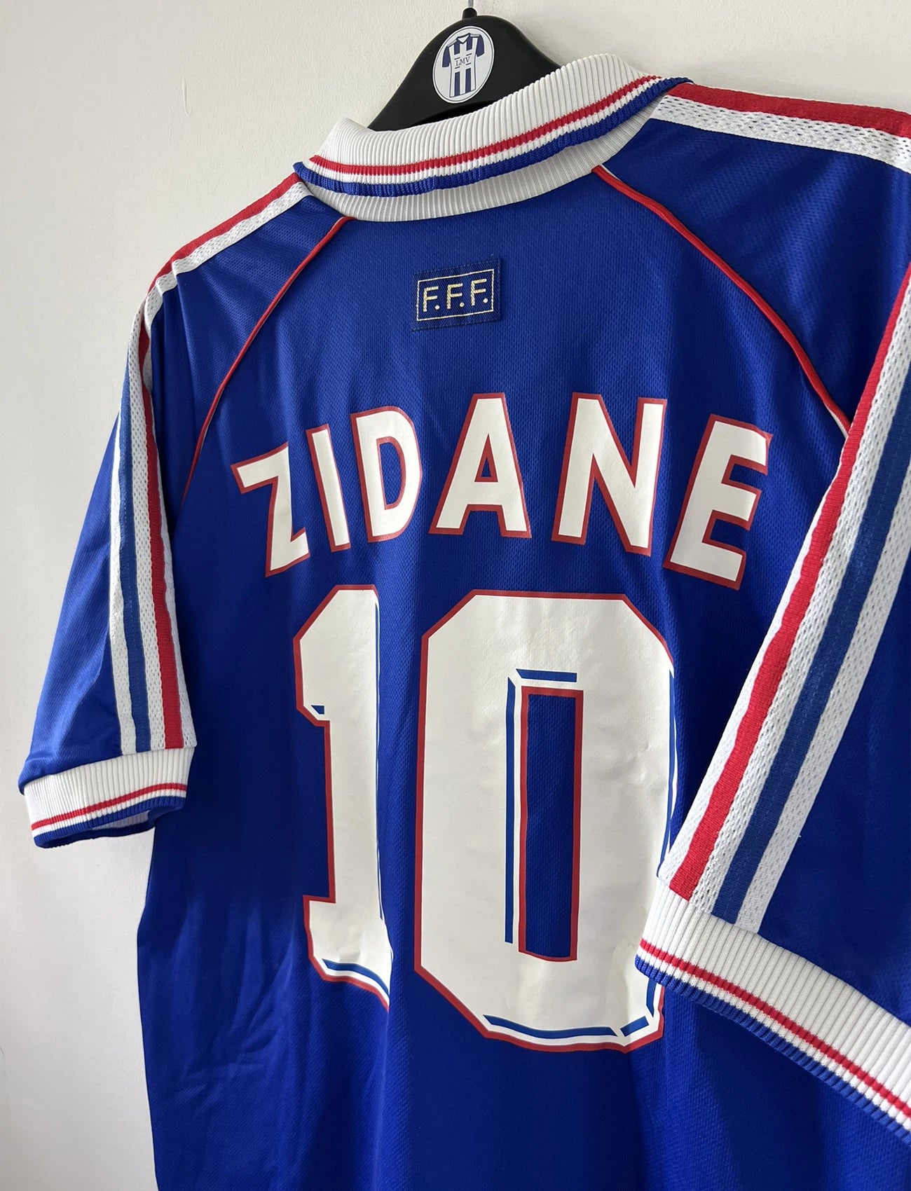 Maillot de foot vintage domicile de l'équipe de france 1998. On peut retrouver l'équipementier adidas. Le maillot est de couleur bleu blanc et rouge. Le maillot est floqué du numéro 10 Zinedine Zidane. Il s'agit d'un maillot authentique d'époque.