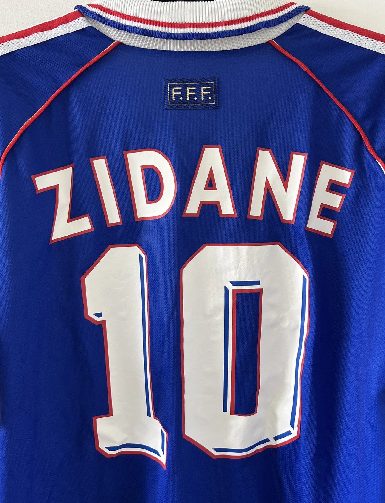 Maillot de foot vintage domicile de l'équipe de france 1998. On peut retrouver l'équipementier adidas. Le maillot est de couleur bleu blanc et rouge. Le maillot est floqué du numéro 10 Zinedine Zidane. Il s'agit d'un maillot authentique d'époque.