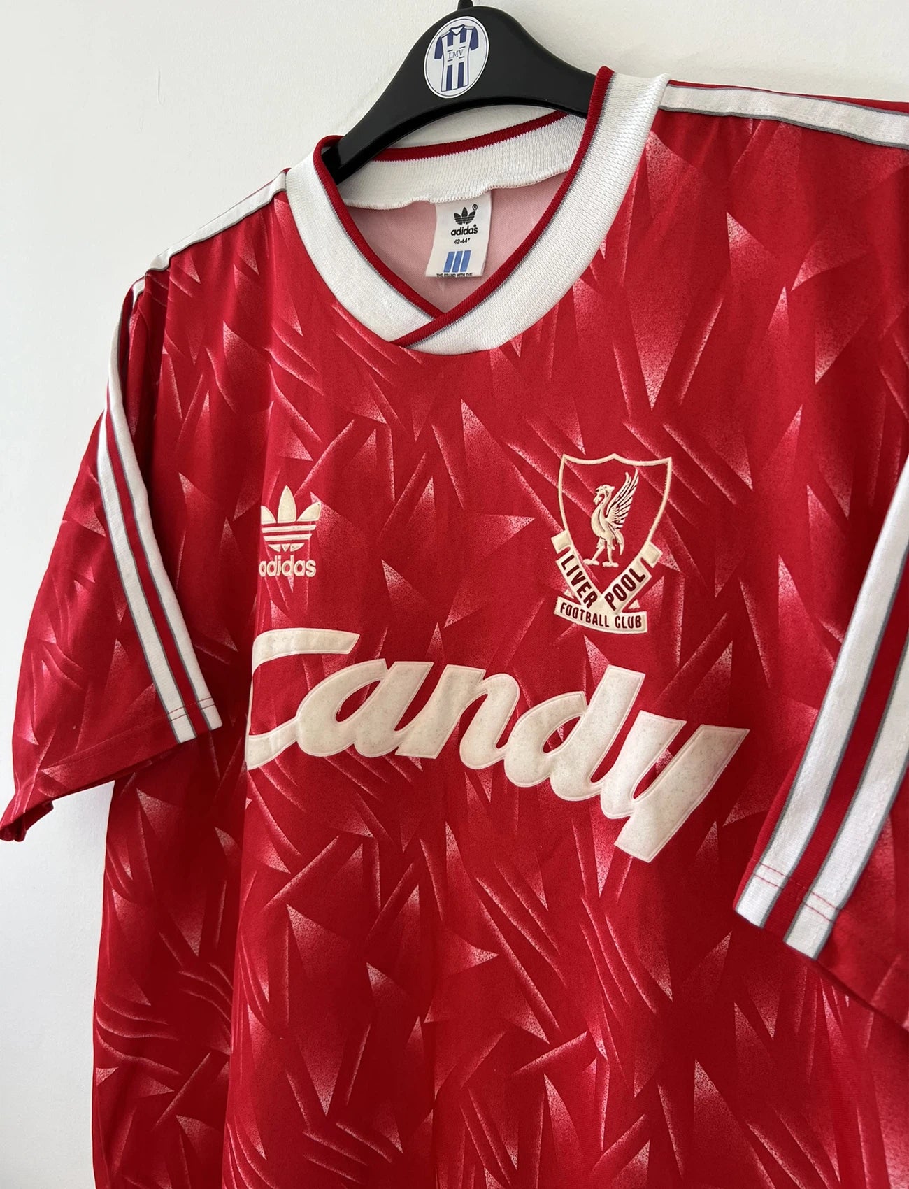 Maillot de foot vintage domicile de liverpool de la saison 1989/1991. Il s'agit du maillot domicile de couleur rouge et blanc. On peut retrouver l'équipementier adidas et le sponsor candy en feutrine. Il s'agit d'un maillot authentique d'époque.