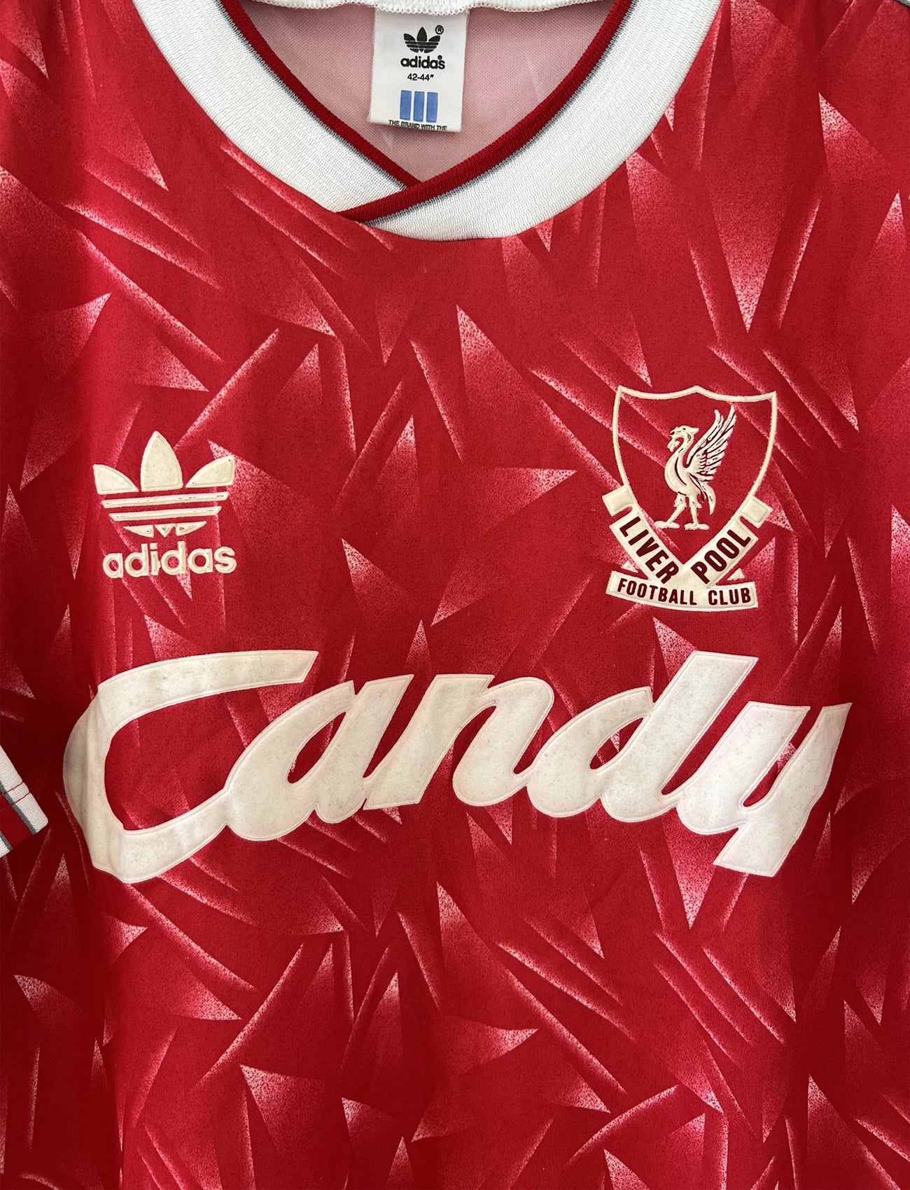 Maillot de foot vintage domicile de liverpool de la saison 1989/1991. Il s'agit du maillot domicile de couleur rouge et blanc. On peut retrouver l'équipementier adidas et le sponsor candy en feutrine. Il s'agit d'un maillot authentique d'époque.